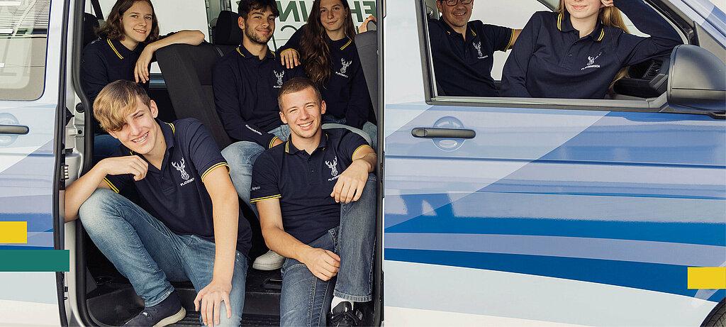 HirschmannAutomotive_Appreticeships_6.jpg aus dem Lehrlingsbüsle steigen zwei Lehrlinge aus